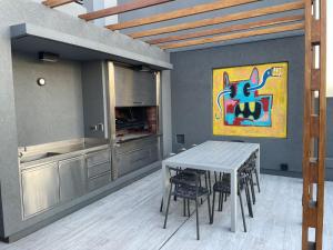 una cocina con mesa, sillas y una pintura en Miravida Soho Apartments en Buenos Aires