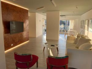 sala de estar con sofá, TV y sillas en Miravida Soho Apartments en Buenos Aires