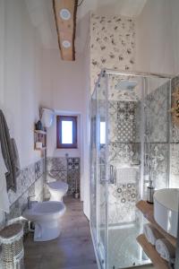 een badkamer met 2 wastafels, een douche en 2 toiletten bij La casa della moda in Montescaglioso