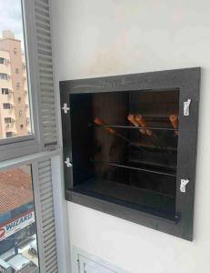 a wall oven with two hot dogs in it at Apartamento 3 suítes 1 quadra do mar in Itapema