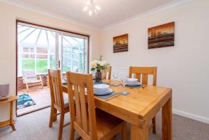 a dining room with a wooden table and chairs at 4 Bed House in Castle Donington (EMA) with parking in Castle Donington