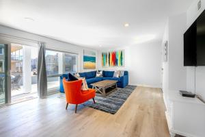 a living room with a blue couch and orange chairs at Newport Temptation in Newport Beach