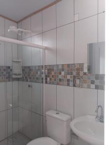 La salle de bains blanche est pourvue de toilettes et d'un lavabo. dans l'établissement Pousada Shamah, à Morro de São Paulo