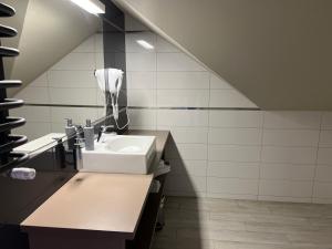 a bathroom with a sink and a hair dryer on the wall at Apartament Czarna Góra - Resort - Solden - Sienna in Sienna