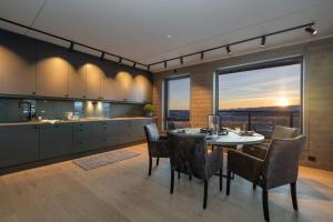 cocina y comedor con mesa y sillas en Splitter ny leilighet med panoramautsikt, en Beitostølen