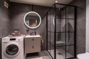 a bathroom with a washing machine and a shower at Splitter ny leilighet med panoramautsikt in Beitostøl