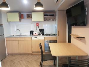 a small kitchen with a wooden table and a table and chairs at Mobil home MAXI CONFORT SUR LA COTE D'AZUR in Fréjus