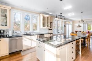 a kitchen with white cabinets and a large island at Beach Blessing in Montauk