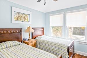 two beds in a room with two windows at Beach Blessing in Montauk