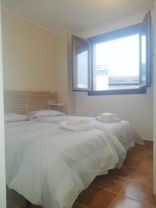 a bedroom with a large white bed with a window at Apartamento Colombres in Colombres