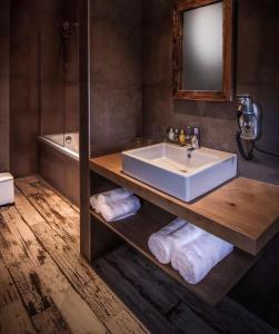 een badkamer met een wastafel, een spiegel en een bad bij Don Jon in Machelen