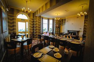Chatsworth House Hotel في خلنددنو: غرفة طعام مع طاولات وكراسي في مطعم