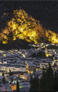 Una ciudad iluminada por la noche con una montaña en Loft Casa del Agua Ubrique, en Ubrique