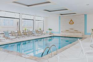 a pool in a hotel with chairs and a swimming pool at Hotel Minas Gerais in Poços de Caldas