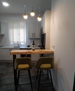 - une cuisine avec une table et 2 chaises ainsi qu'une bouteille de vin dans l'établissement Loft Casa del Agua Ubrique, à Ubrique