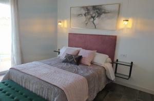 a bedroom with a bed with pillows on it at Loft Casa del Agua Ubrique in Ubrique