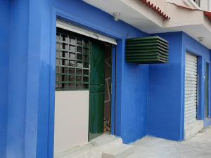 a blue building with a door and a window at Perla's Suites in Guayaquil