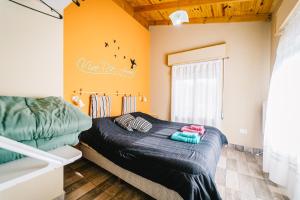 ein Schlafzimmer mit einem Bett in einem Zimmer mit orangefarbenen Wänden in der Unterkunft OHANA in Sierra de la Ventana