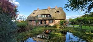 an old stone house with a reflection in a pond at "Haus auf dem Berg" in Westensee
