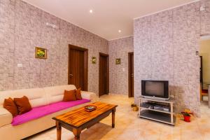 a living room with a couch and a tv at Kotor Emerald Apartments in Kotor