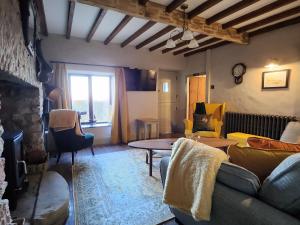 a living room with a couch and a table at 3 Penllan Cottages in Holywell