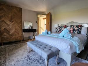 a bedroom with a large bed and a piano at 3 Penllan Cottages in Holywell