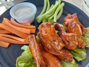 a plate of food with chicken lettuce and carrots and dipping sauce at Las Palmas Hotel - Cerritos Beach in El Pescadero