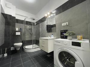 a bathroom with a washing machine and a shower at Luxury Charming Apartments in Iaşi