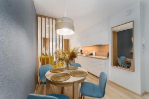 una cucina e una sala da pranzo con tavolo e sedie blu di Apartament SUBMARINE SurfingBird Dźwirzyno a Dźwirzyno