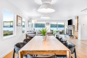 a dining room and living room with a table and chairs at Lopez Island Mud Bay Waterfront home in Islandale