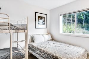 sypialnia z łóżkiem piętrowym i oknem w obiekcie Lopez Island Mud Bay Waterfront home w mieście Islandale
