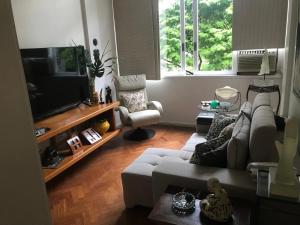 sala de estar con sofá y TV de pantalla plana en Ipanema 3 quartos lindos, en Río de Janeiro