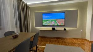 ベオグラードにあるFilip Luxury Suiteの壁にテーブルとテレビが備わる部屋