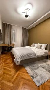 a bedroom with a large bed and a table at Filip Luxury Suite in Belgrade