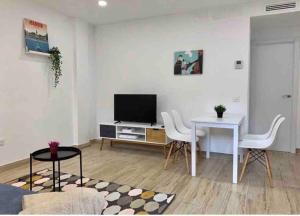 sala de estar con TV, mesa y sillas en Apartamento 4 personas en Madrid