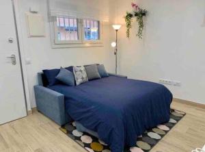 a bedroom with a blue bed and a rug at Apartamento 4 personas in Madrid