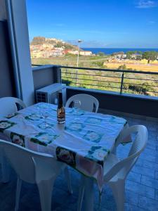 una mesa con una botella de vino en el balcón en Elicriso, en Castelsardo