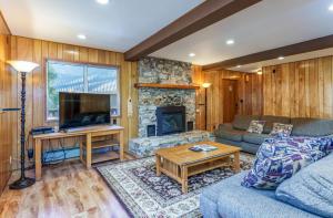 Una sala de estar con un sofá y una chimenea. en Hutchings Cabin & Apt., en Yosemite West