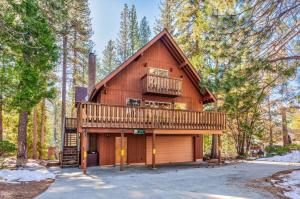 una cabaña en el bosque con terraza en Hutchings Cabin & Apt., en Yosemite West
