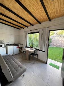 Una sala de estar con una mesa y una cocina. en Andrea Houses, en Chacras de Coria