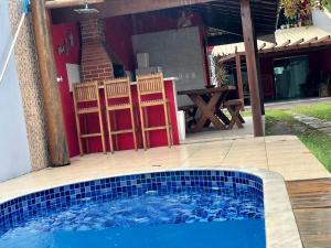 una piscina en un patio trasero con mesa y sillas en Casa espaçosa 15h 800m praia, en Porto Seguro
