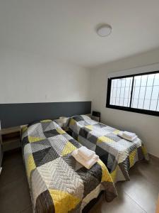 two twin beds in a room with a window at Andrea Houses in Chacras de Coria