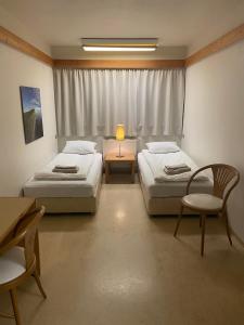 Zimmer mit 2 Betten, einem Tisch und Stühlen in der Unterkunft Dalahótel in Laugar