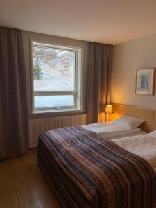 ein Hotelzimmer mit 2 Betten und einem Fenster in der Unterkunft Dalahótel in Laugar