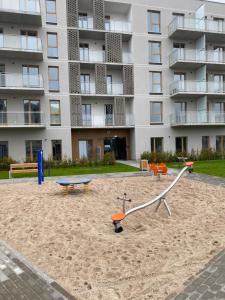 a sand playground in front of a building at Apartamenty Sonata, Mazury, Szczytno in Szczytno