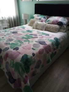 Una cama con un edredón colorido. en Sunbrae Beach Two rooms en Mount Maunganui