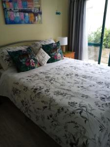 a bedroom with a bed with a white comforter at Two rooms with one queen size bed in each room one bathroom for the two rooms in Mount Maunganui