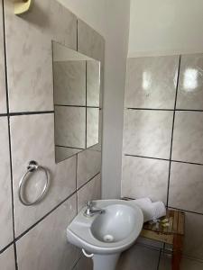 a bathroom with a white sink and a mirror at Pousada São Jorge in Bonito