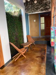ein Zimmer mit zwei Bänken und einer grünen Wand in der Unterkunft Sierra Norte By Chic Hotel Group in Tepoztlán