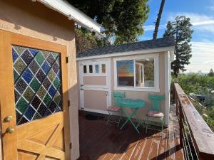 a tiny house with a door and chairs on a deck at Glamping Hollywood Hills - Luxury Tiny House in Los Angeles
